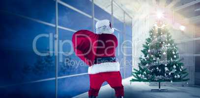 Composite image of rear view of santa holding a sack