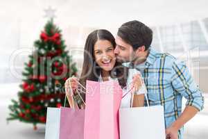 Composite image of happy couple with shopping bags