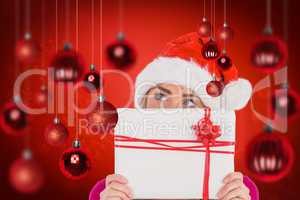 Composite image of festive blonde holding christmas gift