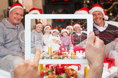 Composite image of hand holding tablet pc