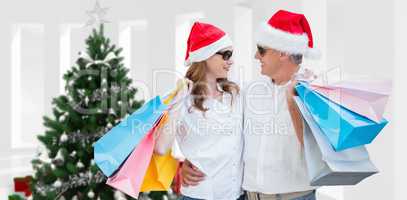 Composite image of christmas couple with shopping bags