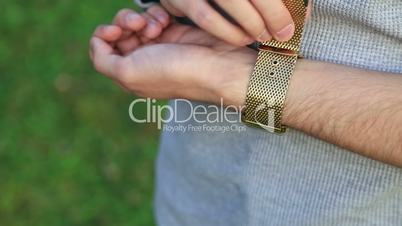 Man clasping his wrist watch