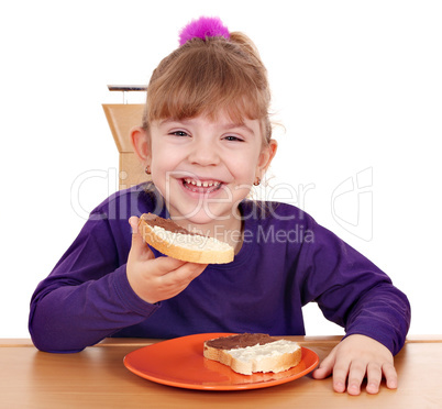 happy little girl eats bread with chocolate