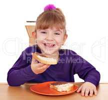 happy little girl eats bread with chocolate