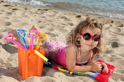 little girl with sunglasses on the beach