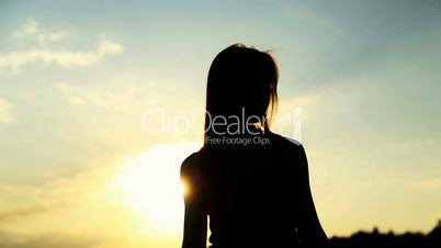 Silhouette of the woman dancing during beautiful sunset. Natural light and darkness.