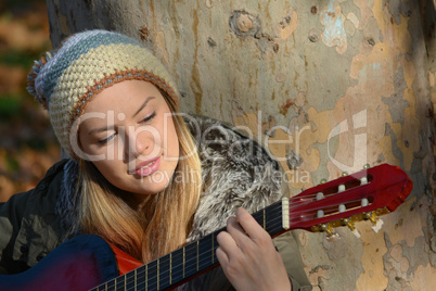 Girl with woolen cap and guitar