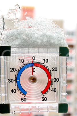 thermometer with layer of snow showing two degrees