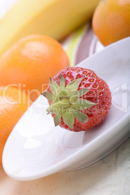 Fresh colorful fruits composition mandarin, strawberry, peach, bananas and orange