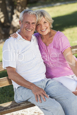 Happy Senior Couple Sitting on Bench in Sunshine