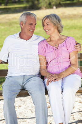 Happy Senior Couple Sitting on Bench in Sunshine