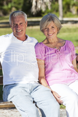 Happy Senior Couple Sitting on Bench in Sunshine