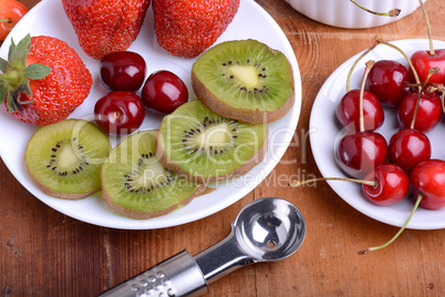 fruit with cherry, strawberry, kiwi on wooden plate