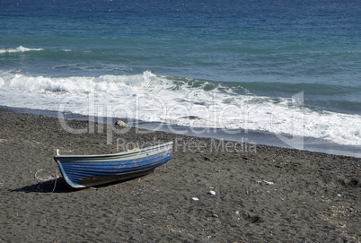 boat on volcanic beach on santorini siland