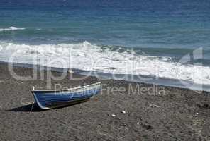 boat on volcanic beach on santorini siland