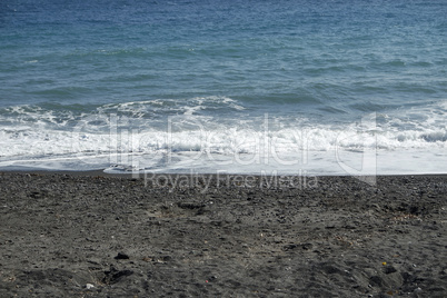 volcanic beach in kamari on santorini siland