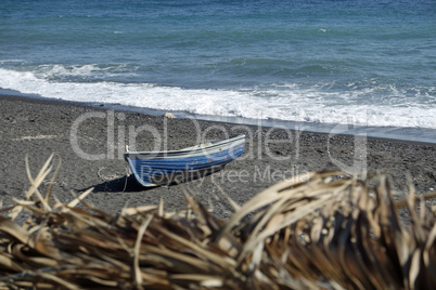 boat on volcanic beach on santorini siland