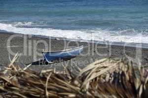 boat on volcanic beach on santorini siland