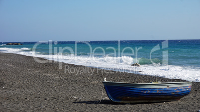 boat on volcanic beach on santorini siland