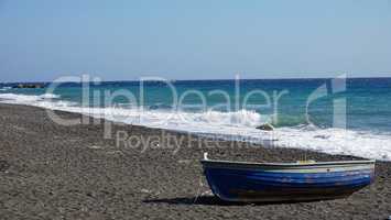 boat on volcanic beach on santorini siland