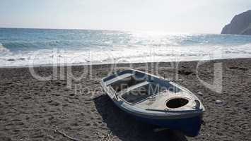 boat on volcanic beach on santorini siland