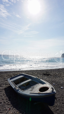 boat on volcanic beach on santorini siland