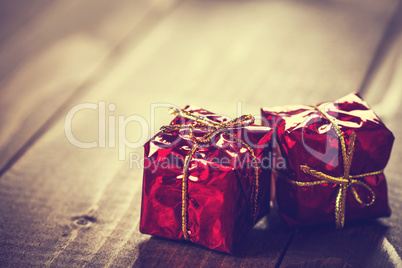 Christmas gift box with red ribbon on dark wooden background in vintage style