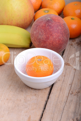 Mandarin Apples Bananas Peach on wooden plate