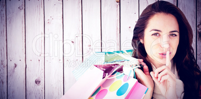 Composite image of woman wearing a scarf and holding shopping ba