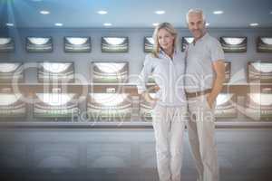 Composite image of couple standing with hands in pocket