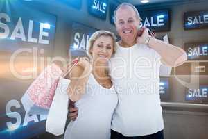 Composite image of couple with shopping bags