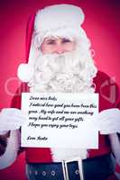 Composite image of cheerful santa claus holding page