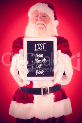 Composite image of santa presents a tablet pc