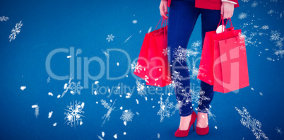 Composite image of happy brunette in winter clothes holding shop