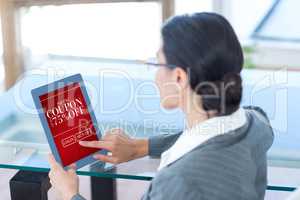 Composite image of businesswoman using digital tablet in office