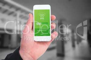 Composite image of hand of businessman holding smart phones