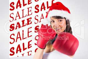 Composite image of festive brunette punching with boxing gloves