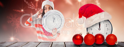 Composite image of thoughtful brunette holding a clock