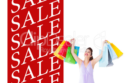 Composite image of smiling brunette showing shopping bags
