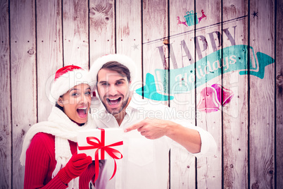 Composite image of festive young couple holding gift