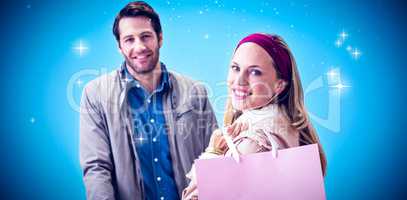 Composite image of smiling woman with shopping bag in front of c