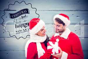 Composite image of festive young couple holding gift