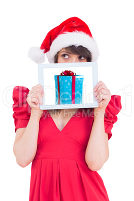 Composite image of festive brunette holding a tablet pc