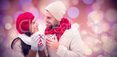 Composite image of winter couple holding mugs