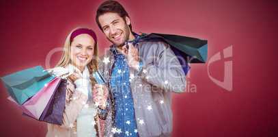 Composite image of smiling couple with shopping bags in front of