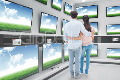 Composite image of attractive young couple standing with arms ar