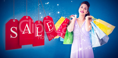 Composite image of thoughtful brunette holding shopping bags