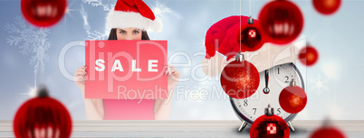 Composite image of brunette in red dress holding sale sign