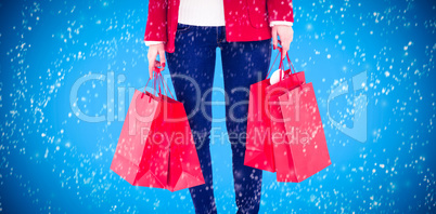 Composite image of smiling brunette in winter clothes holding sh