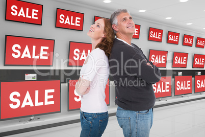 Composite image of casual couple smiling and looking up